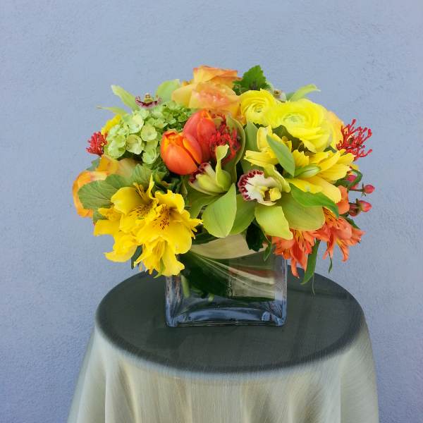 Bright mixed bouquet in a square glass vase