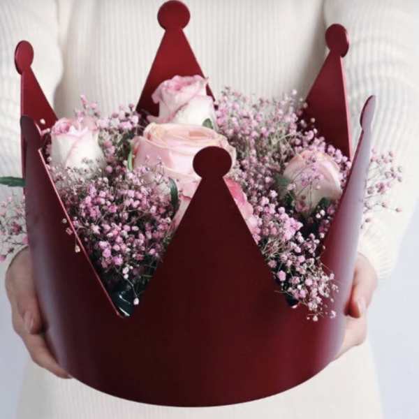 Pink roses in a burgundy crown-shaped bouquet holder