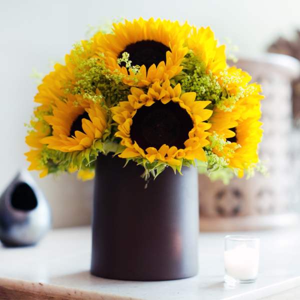 Sunflower arrangement in a dark cylindrical vase