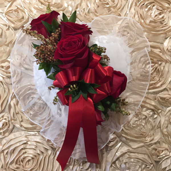 Red rose bouquet with a large red ribbon on white tulle