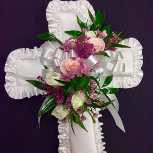 White satin cross with pink and white flowers