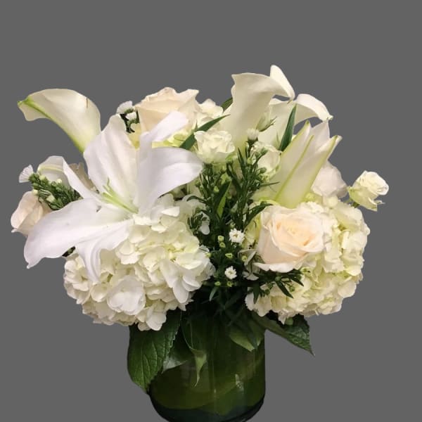 White lilies and roses arranged in a glass vase