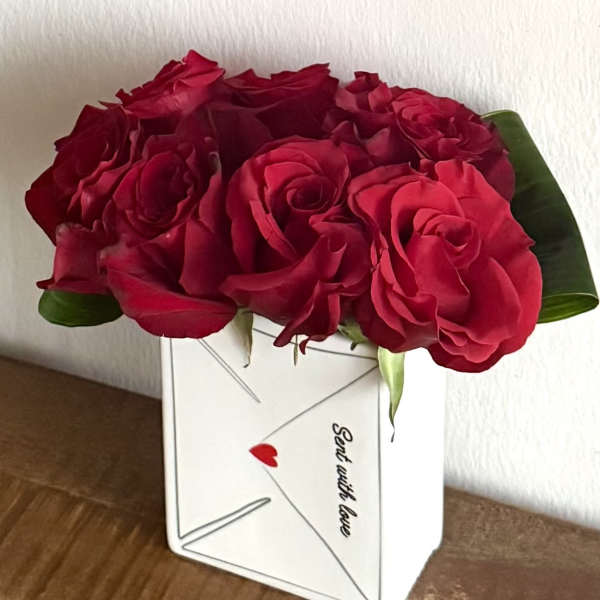 Red roses arranged in a white envelope-shaped box