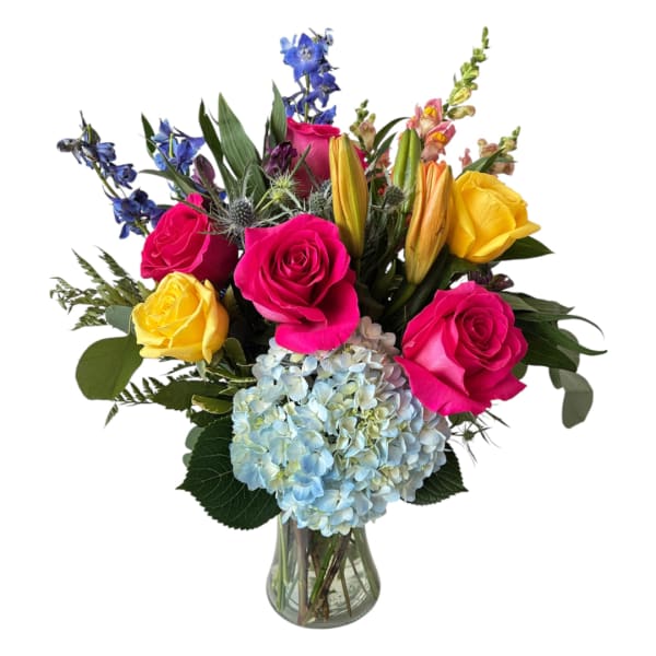 Mixed bouquet of pink and yellow roses with blue hydrangea in a glass vase