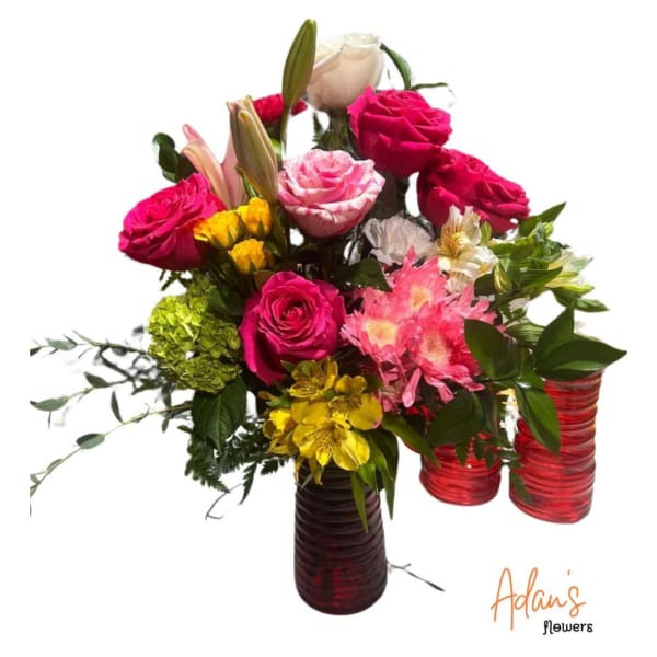 Mixed bouquet of pink, white, and yellow flowers in red glass vases