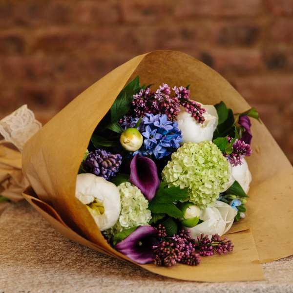 Bouquet of mixed flowers wrapped in brown paper
