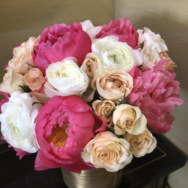 Bouquet of pink and cream peonies and roses in a metallic vase