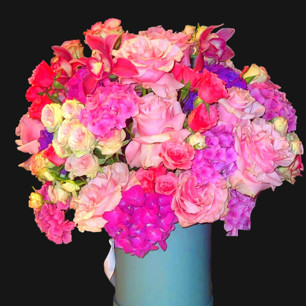 Large bouquet of pink and purple flowers in a blue hatbox