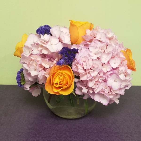 Pink hydrangeas with yellow roses in a glass vase