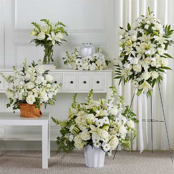 White floral funeral arrangements with lilies and roses in vases and stands