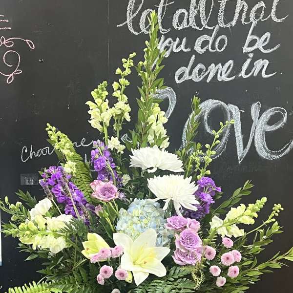 Large mixed floral arrangement in a white pedestal vase