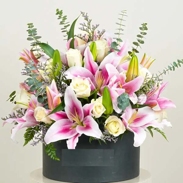 Pink lilies and white roses arranged in a black box