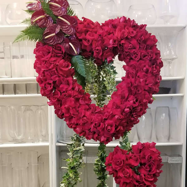 Heart-shaped floral stand with red roses and purple anthuriums