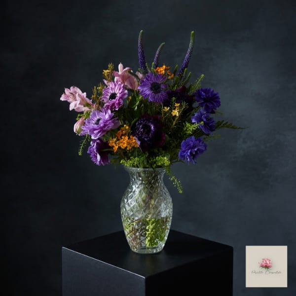 Purple and pink mixed bouquet in a clear glass vase