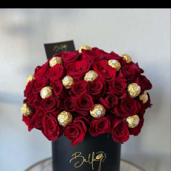 Red roses with gold-wrapped chocolates in a black hat box