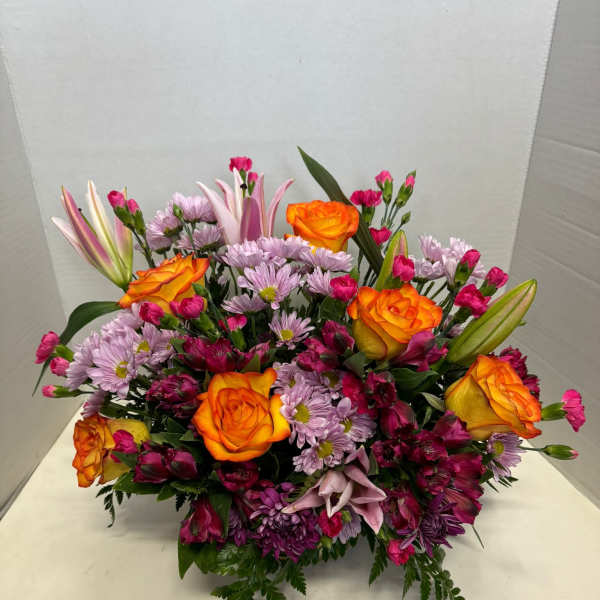 Mixed bouquet with orange roses, pink lilies, and purple daisies