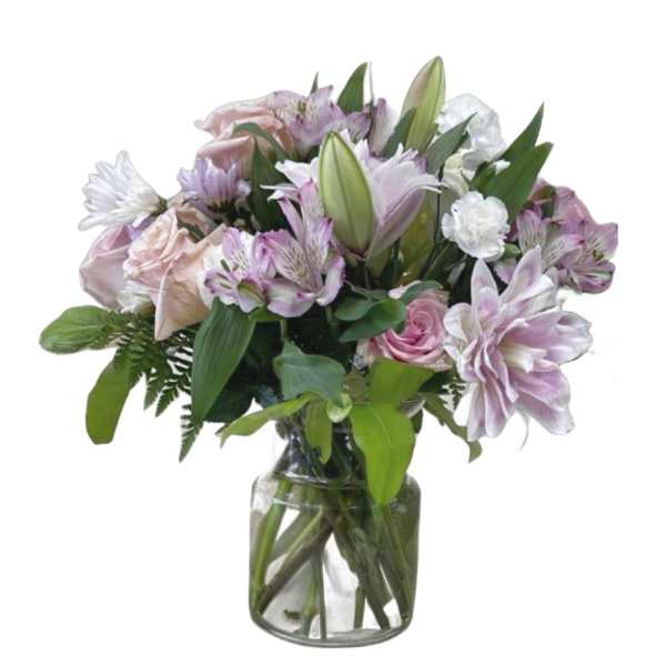 Mixed pink and white flowers arranged in a clear glass vase