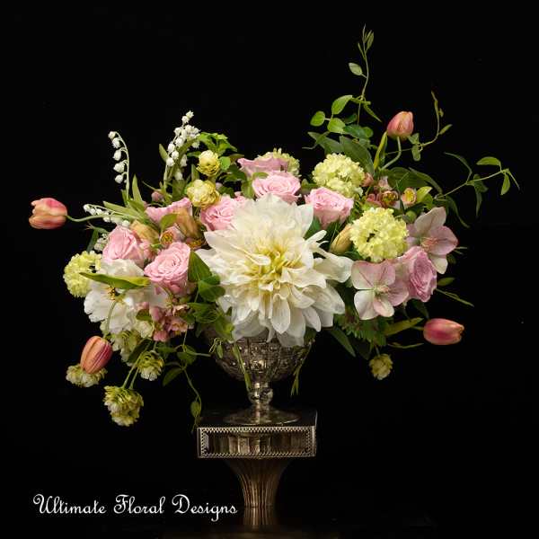 Pink and white floral arrangement in a silver pedestal vase
