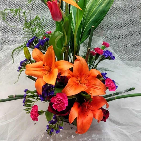 Tall tropical bouquet with orange lilies and pink tulips