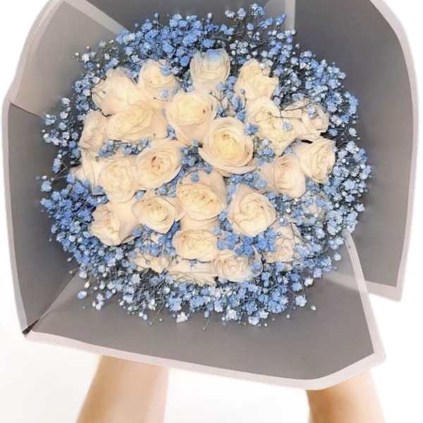 Bouquet of cream roses with blue baby's breath in gray wrap