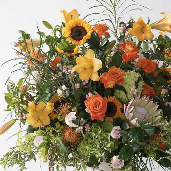 Large mixed bouquet with sunflowers, lilies, roses, and protea