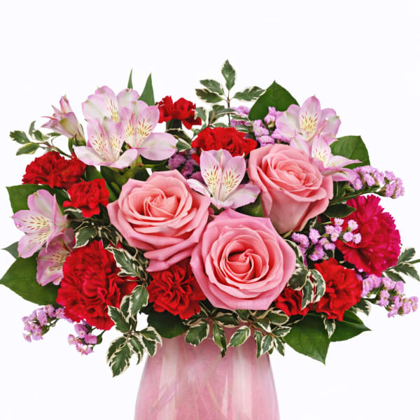 Pink roses and red carnations in a glass vase