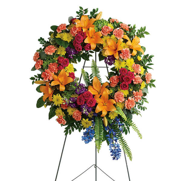 Colorful floral wreath on a black easel stand