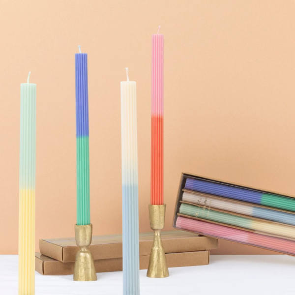Four ribbed pastel taper candles with gold holders and a boxed set