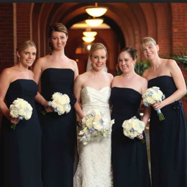 Bride and bridesmaids holding white rose bouquets