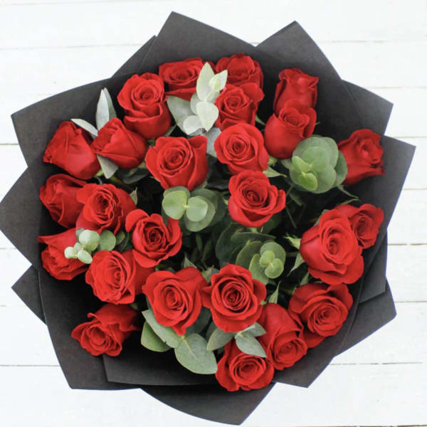 Bouquet of red roses wrapped in black paper