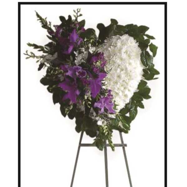 Standing funeral spray with white and purple flowers on an easel