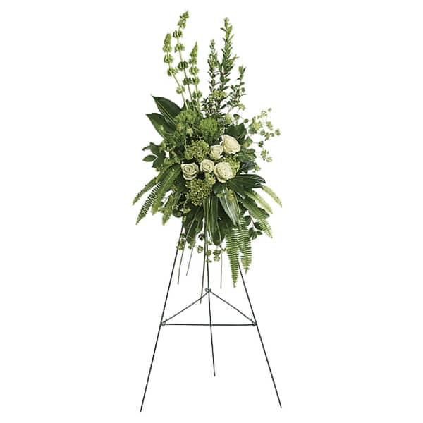 Standing floral spray with white roses and greenery on a metal easel