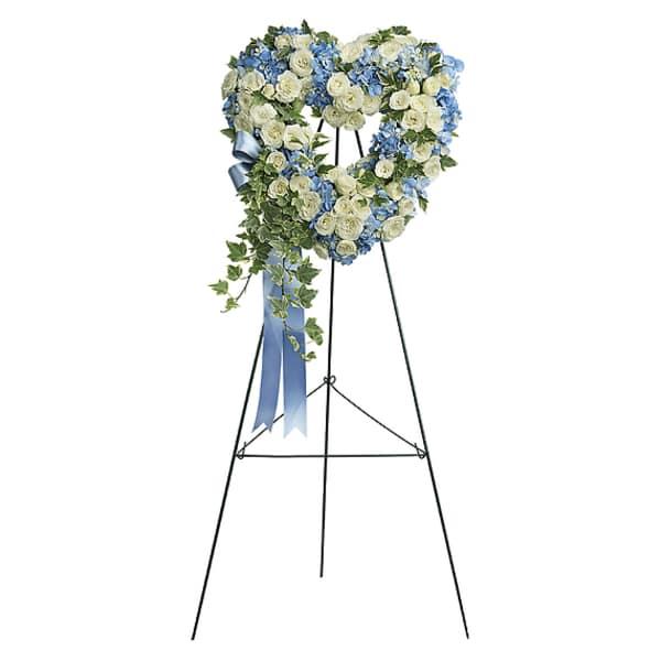 Heart-shaped floral wreath on a black easel with blue ribbon