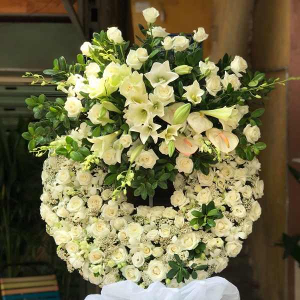 Large white floral standing spray with roses and lilies