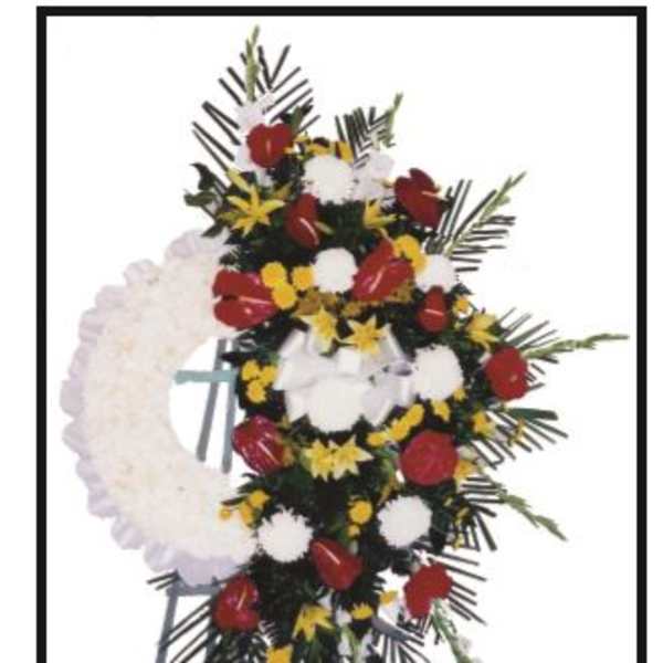 Standing floral wreath with red, white, and yellow flowers on an easel