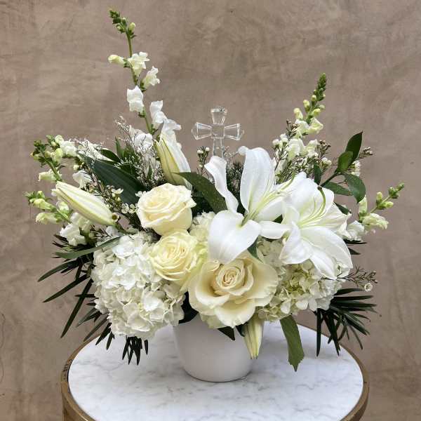 White floral arrangement with roses, lilies, and hydrangeas in a white vase