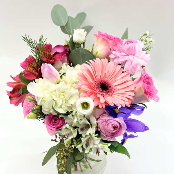 Mixed bouquet in a clear glass vase with pink and white blooms