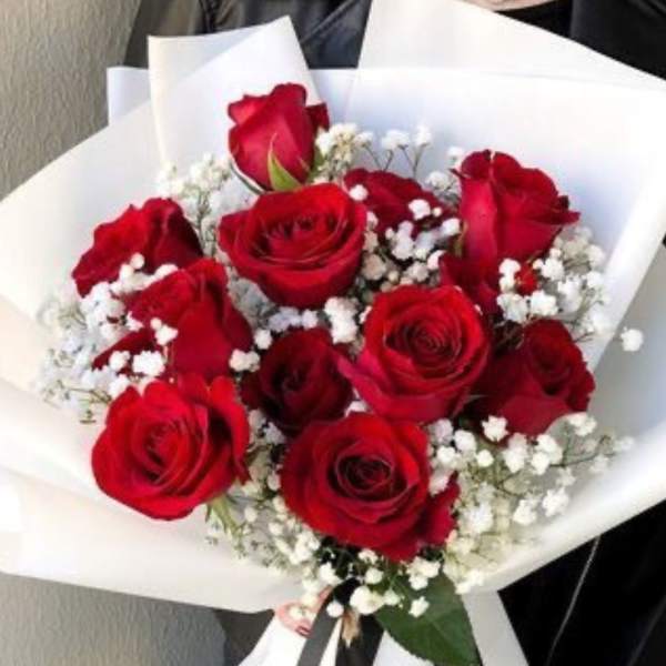 Bouquet of red roses with white baby's breath wrapped in white paper