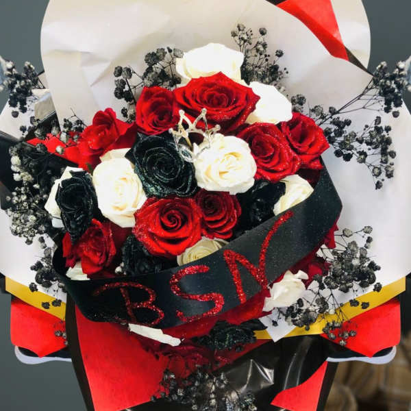 Bouquet of red, white, and black roses with decorative wrapping