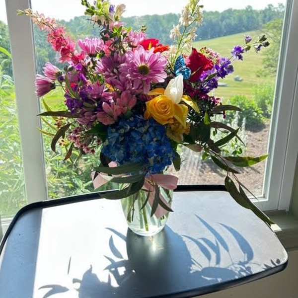 Mixed bouquet of colorful flowers in a clear glass vase