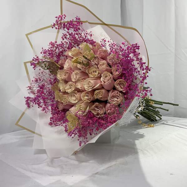 Bouquet of blush roses with bright pink filler flowers