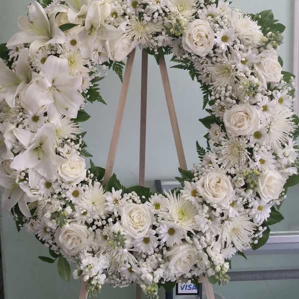 White floral wreath on a wooden easel