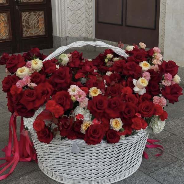 Large white basket filled with red and pink roses