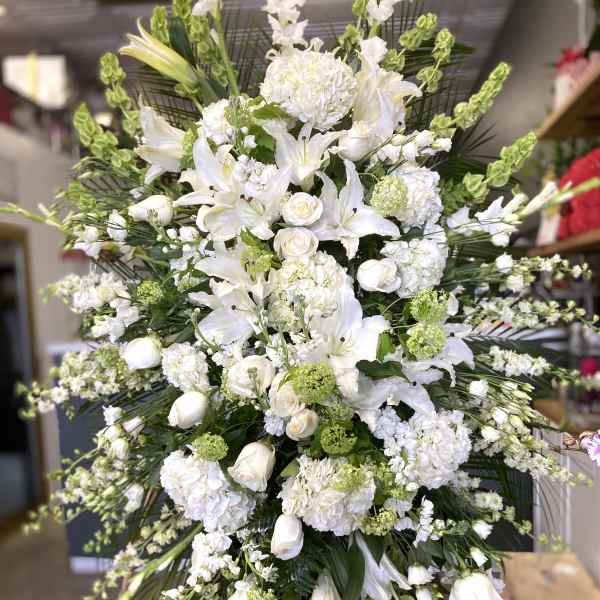 Large white floral standing spray with lilies and roses