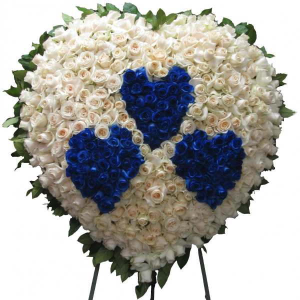 Heart-shaped floral tribute of white and blue roses on a stand
