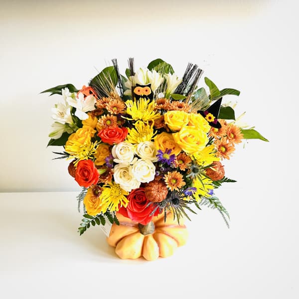 Mixed bouquet of roses and chrysanthemums in a pumpkin-shaped container