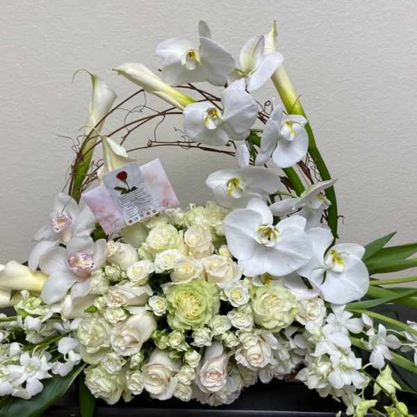 White orchid and rose floral arrangement in a woven basket