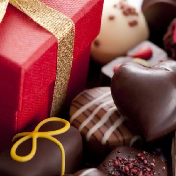 Boxed chocolates with red gift boxes and ribbon