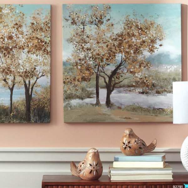 Wall art of trees above a console table with bird figurines and a lamp