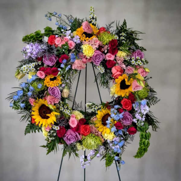 Large colorful floral wreath on a black stand